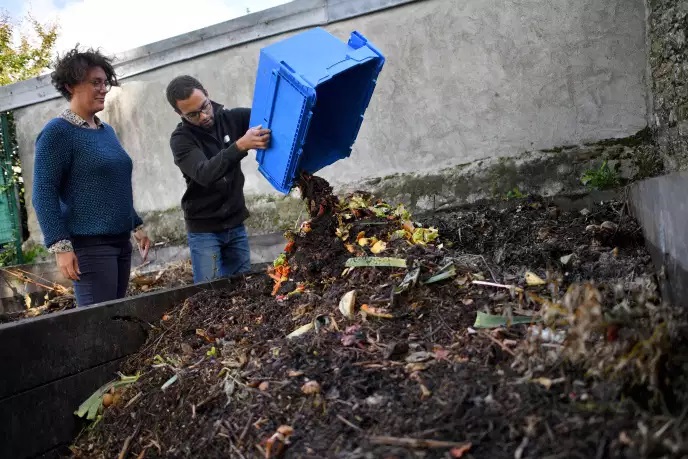 жители пополняют органическими отходами компостную яму в г. Нант,